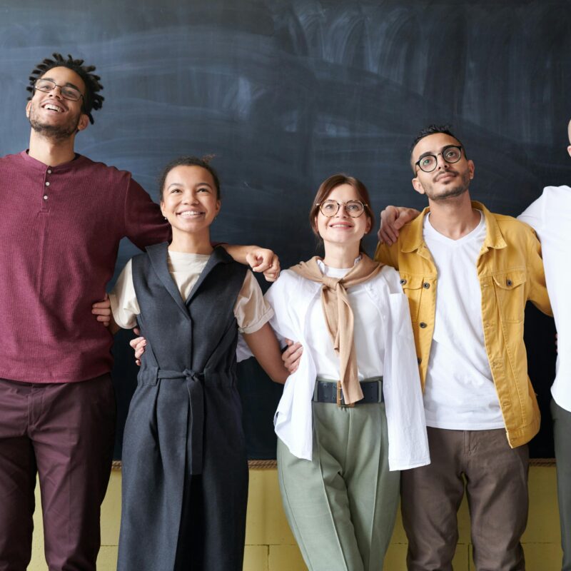 Group of people standing in front of a chalk board looking up